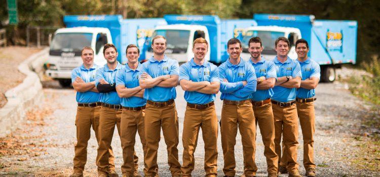 junk removal crew standing in front of their trucks in prosper texas