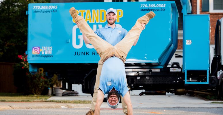 two junk removal experts standing in front of truck in highland park texas