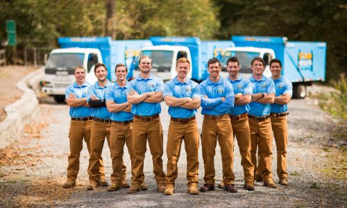 stand up guys junk removal crew standing in front of our trucks in highland park