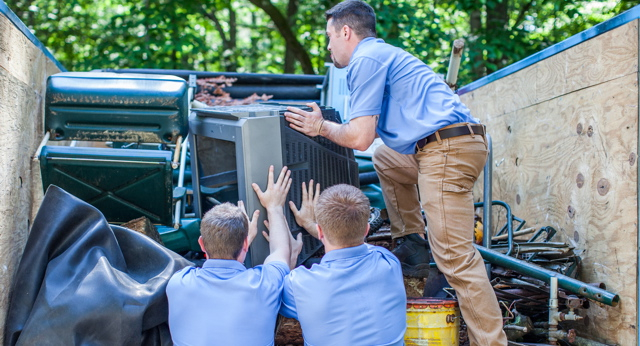 men loading junk into truck